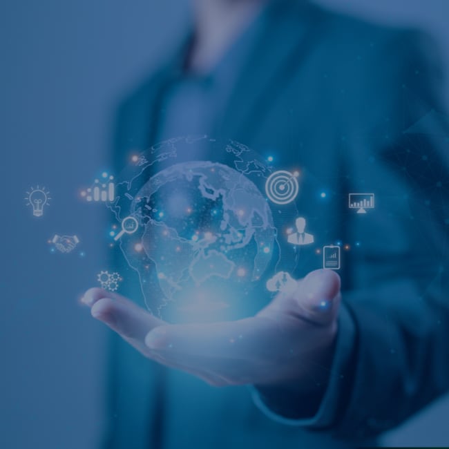 A man in a suit holds a holographic globe with various icons orbiting it.